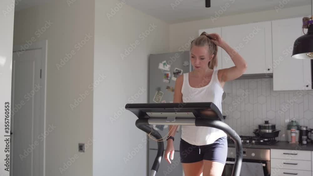 Woman running on running machine at home Woman running on running machine at home