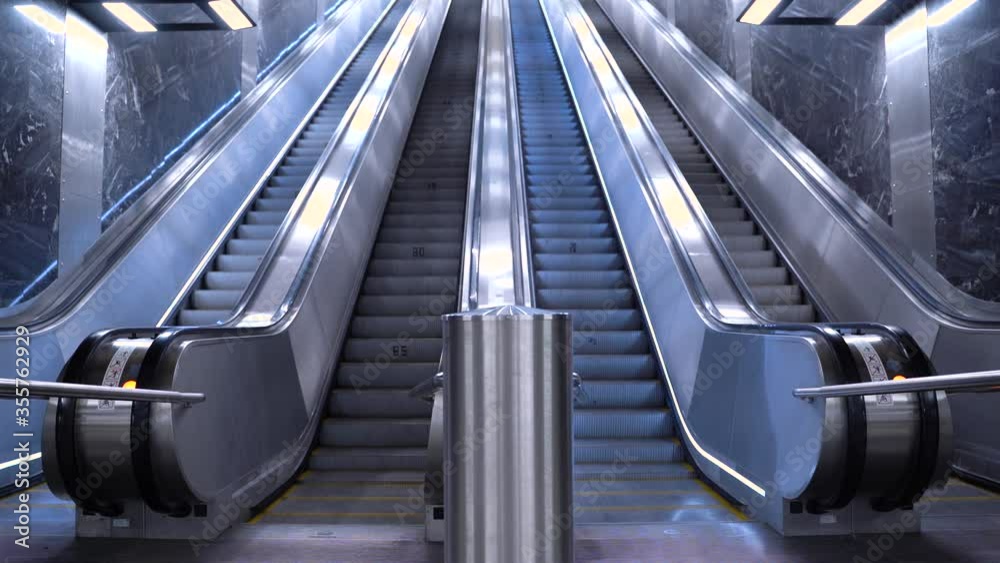 Escalator at the metro station. Escalator in the subway. Empty moving staircase running up and down. Modern escalator stairs, which moves indoor. Escalator at the metro station. Escalator in the subway. Empty moving staircase running up and down. Modern escalator stairs, which moves indoor.