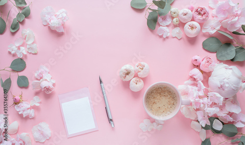 Flowers composition. Empty card, cup of cofee, pen, scissors, and pink flowers on pastel pink background. Flat lay, top view, vertical image.