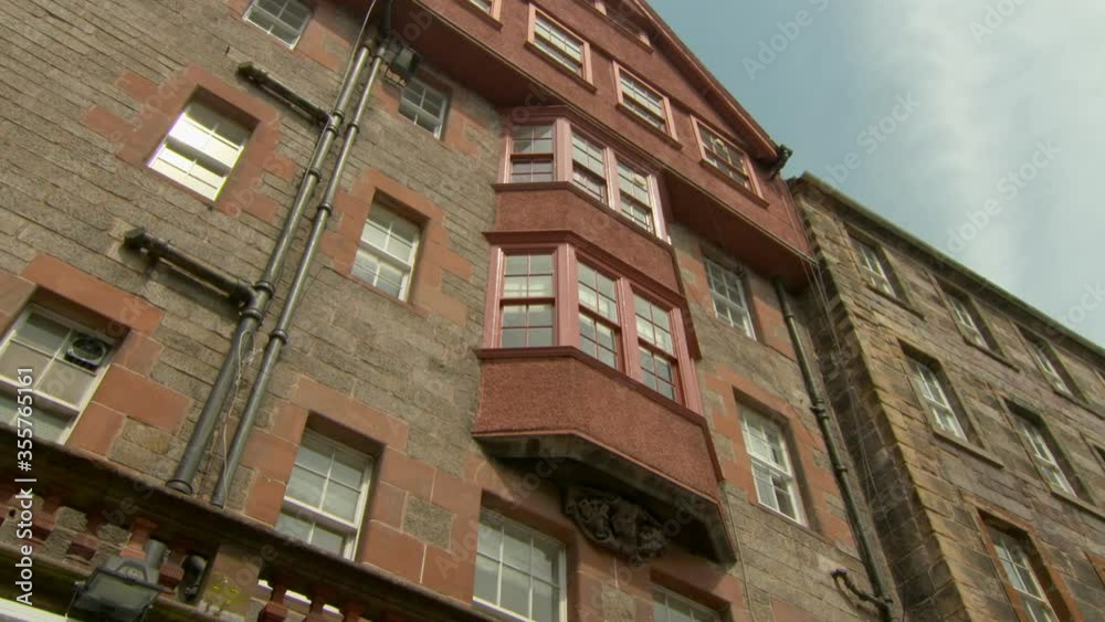 Low angle panning shot of buildings in city against sky on sunny day - Edinburgh, Scotland