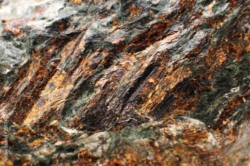 Gold mine. Rock with gold veins on its surface. Selective focus