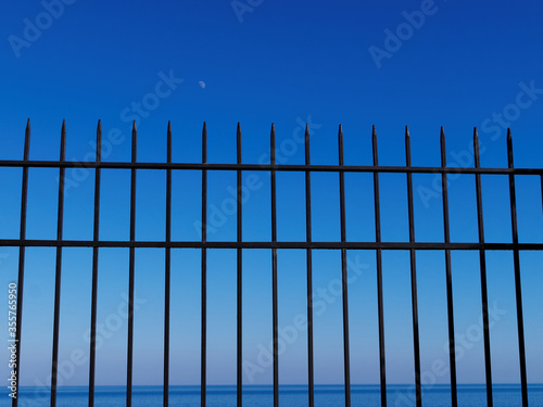 Sea beyond the fence at sunset   