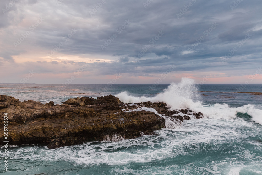 waves crashing on rocks at sunset waves crashing on rocks at sunset