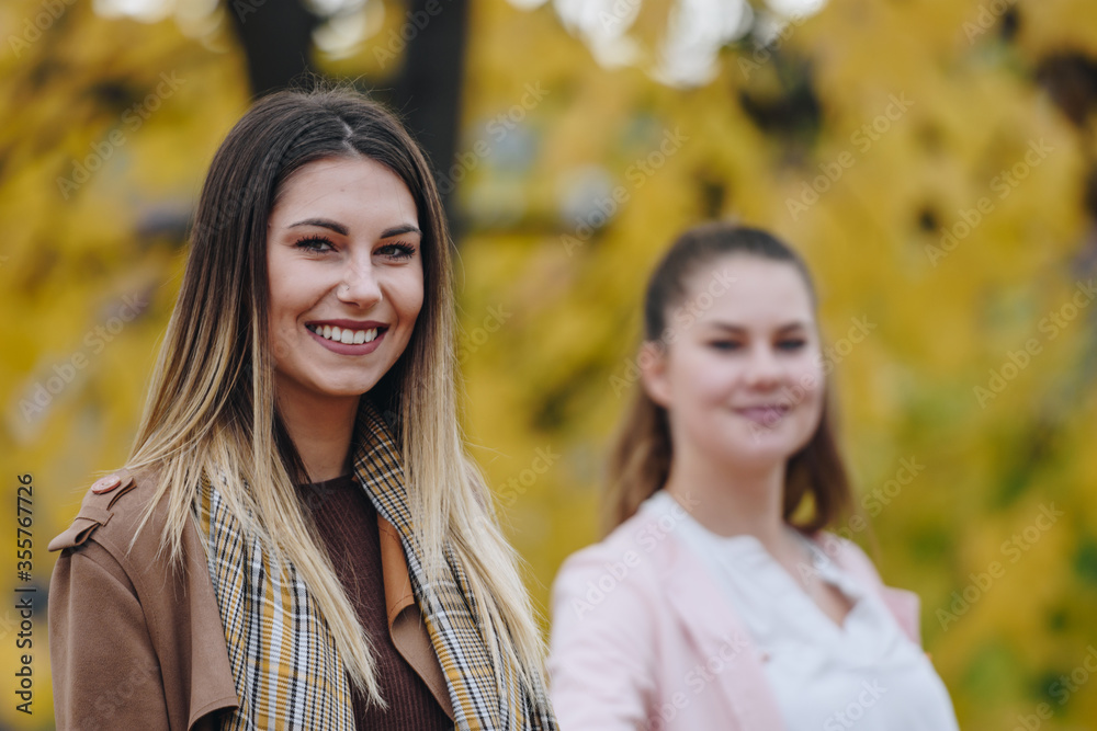 two women posing for pictures on a beautiful autumn day two women posing for pictures on a beautiful autumn day