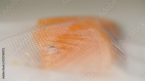 Vacuum packing raw salmon fish fillet into airtight pouch for long term freshness. 