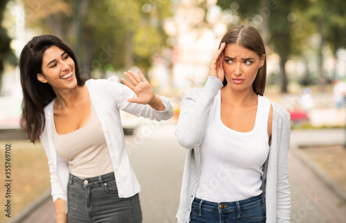 Shy Girl Avoiding Meeting Friend Having Communication Problems Walking Outdoors photo