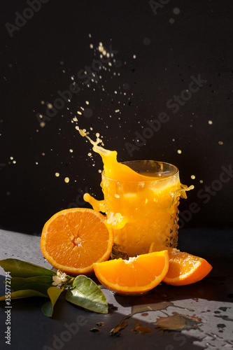 orange juise splash in the bright sun with black background photo