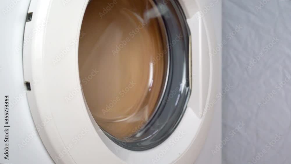 Washing machine wrings things out. side view. The washing machine is moving Washing machine wrings things out. side view. The washing machine is moving