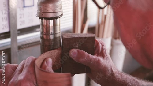Professional guitar maker bending wood for acoustic guitar body. Workshop labour in Madeira