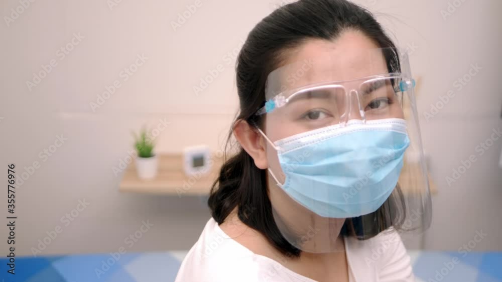 Portrait of an Asia young female who is wearing a face shield with mask rounded around her face from a frontal perspective to protect her glasses and eyes, scene of slow motion.4K 23.97fps Portrait of an Asia young female who is wearing a face shield with mask rounded around her face from a frontal perspective to protect her glasses and eyes, scene of slow motion.4K 23.97fps