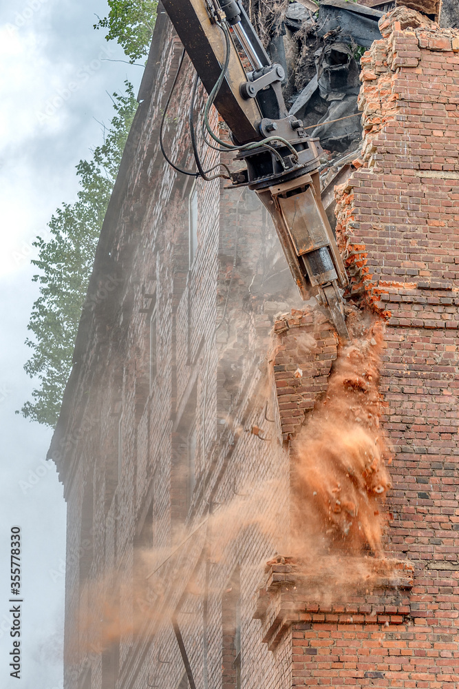 Excavator destroyer breaks a brick wall. Excavator destroyer breaks a brick wall.