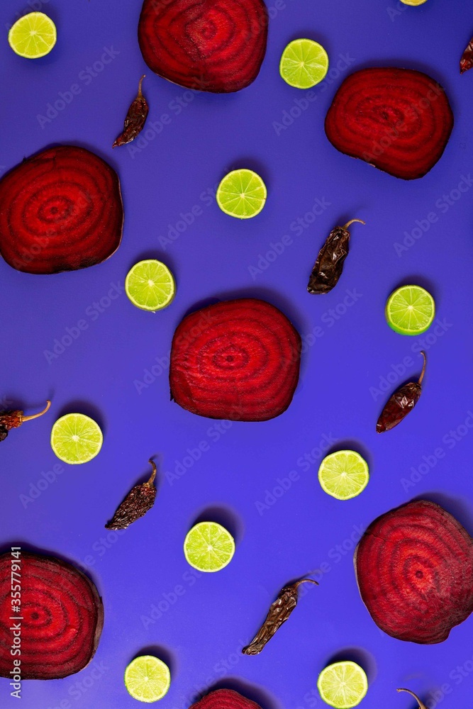 Beetroot in the form of a pattern with lemon slices on a purple background