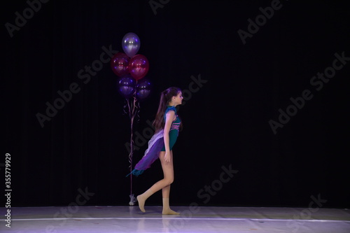 Young teenage girl performing modern dance on stage