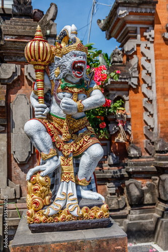 Statue of Hanuman, Hindu god and divine monkey (vanara) companion of the god Rama, holding gada (mace). Bali, Indonesia. Vertical image. photo