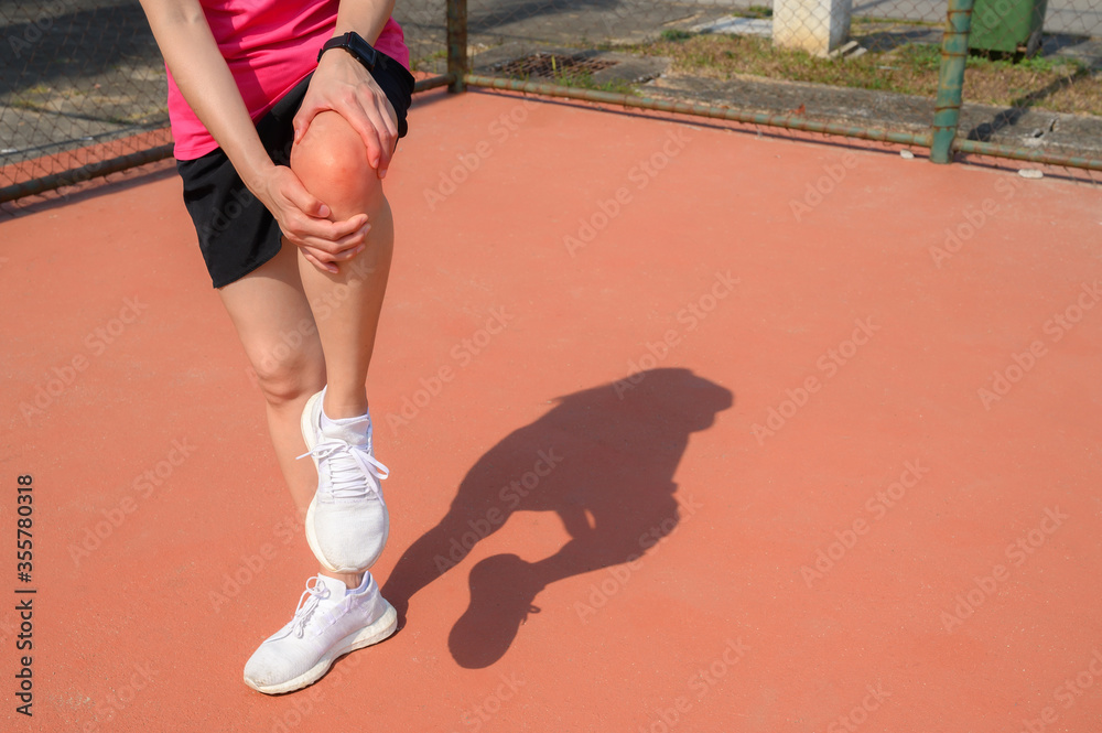 Cropped shot of woman runner suffering from knee pain. It often happens when your kneecap is out of alignment. Conceptual of common running injuries. Cropped shot of woman runner suffering from knee pain. It often happens when your kneecap is out of alignment. Conceptual of common running injuries.