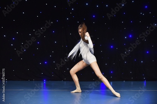 Young teenage girl in white jersey perform modern dance