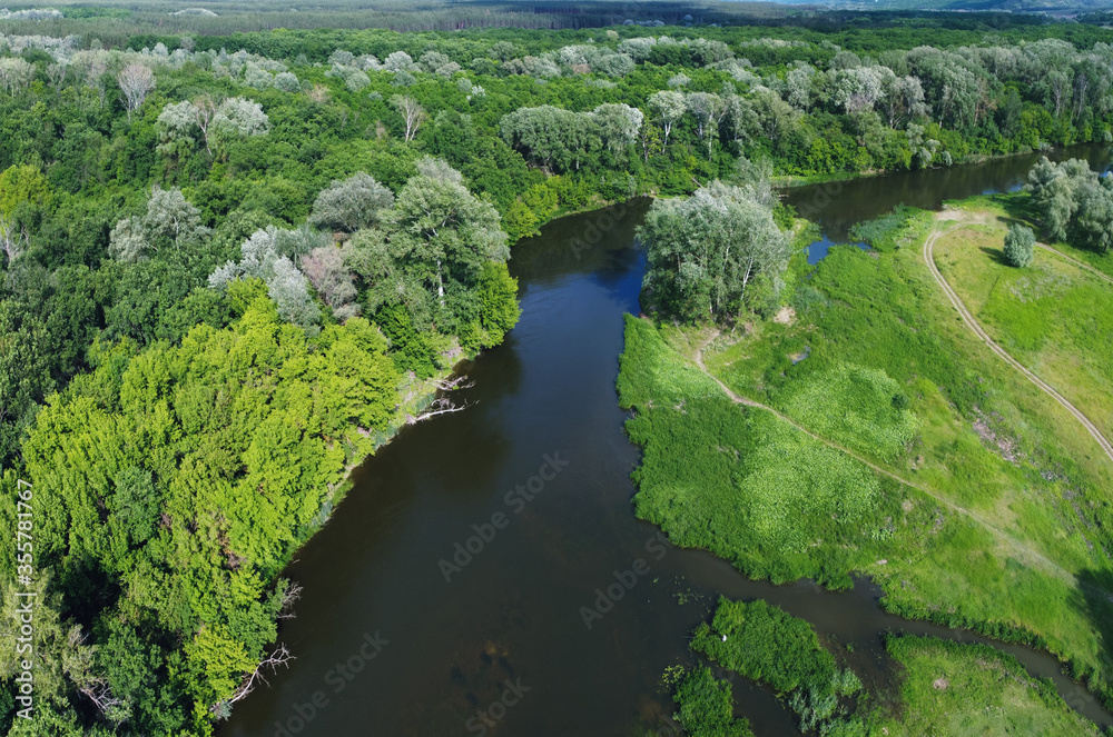 Scenery with river and forest from aerial view. Green bushes on riversides. Scenery with river and forest from aerial view. Green bushes on riversides.