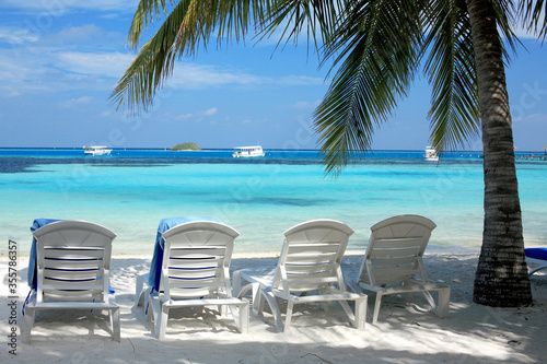 beach chairs and umbrellas on the beach © maodoltee