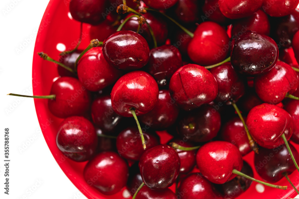 Fresh ripe cherries in colander, close up, view from above Fresh ripe cherries in colander, close up, view from above