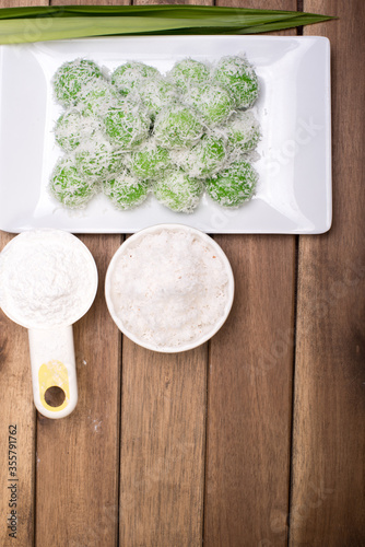 Traditional Malaysian,Indoensian and Singaporean cuisine known as Buah Melaka or Ondeh-ondeh,isolated over wooden background photo