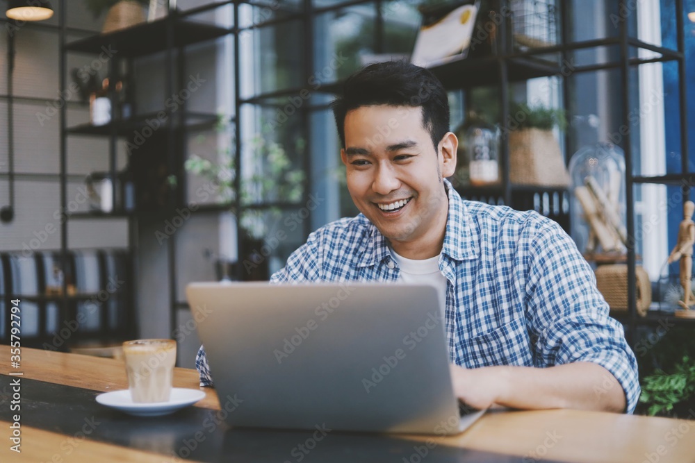 Smiling Asian man with laptop. Smiling Asian man with laptop.