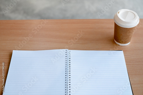 Stationary and blank books on the table  pencil set  cup of coffee and calculator on wood table   copy space of stationary   working space  space work from home