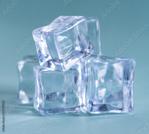 Pile of plastic ice cubes isolated on blue background
