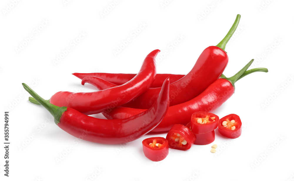 Cut and whole red hot chili peppers on white background