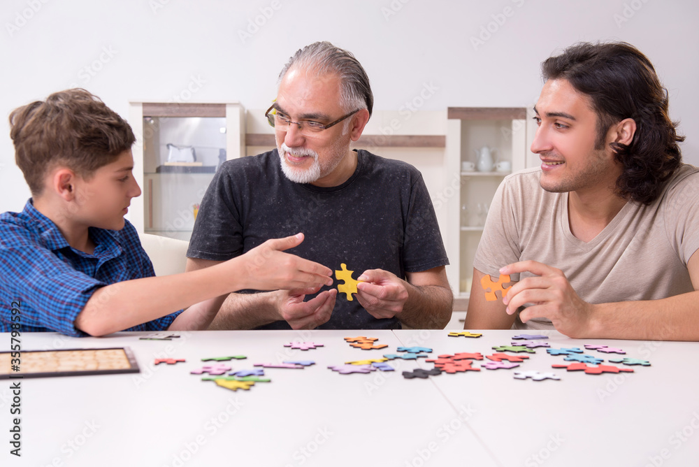 Three generations of family playing jigsaw puzzle game Three generations of family playing jigsaw puzzle game