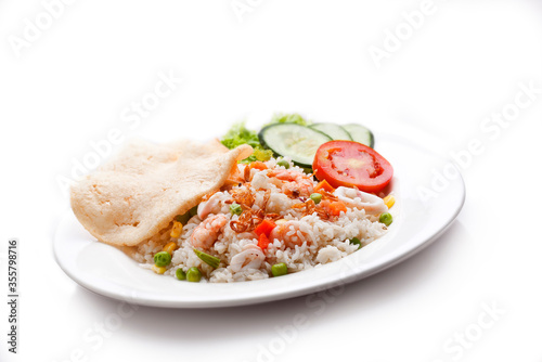 Seafood fried rice. Cooked white rice seasoning, shrimp, sliced squid, peas, corn kernels. Sliced with cucumbers, tomatoes, lettuce and crackers.