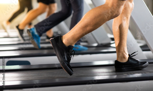Man running on treadmill machine at gym sports club. Fitness Healthy lifestye and workout at gym concept. Selective focus at mele shoe.