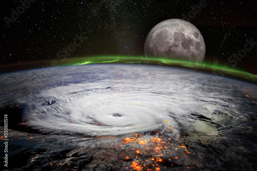 Fototapeta Naklejka Na Ścianę i Meble -  View from space of a giant hurricane over the ocean with full moon rise in background. Elements of this image furnished by NASA.