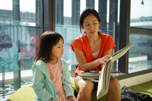 Photography Asian Chinese Mother and Daughter reading books in the library