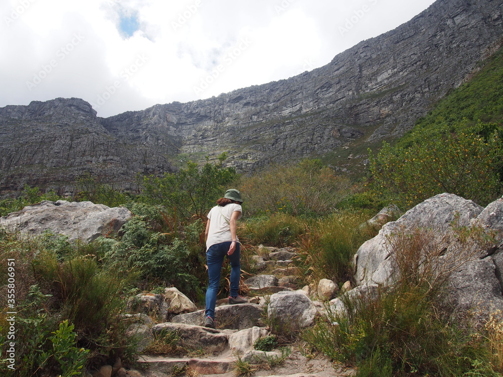A woman walking along the mountain path leading to the top of Table Mountain, Cape Town, South Africa