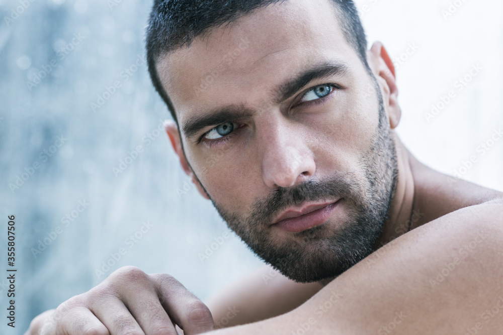 Obraz premium Sexy portrait of topless handsome male model with amazing beautiful blue eyes. Closeup beauty shot.