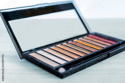 Palette of eyeshadows in brown tones  matte and shimmer eyeshadows on a white background  close up. Female decorative cosmetics. Shallow depth of field.