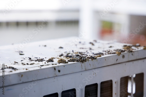 Closeup bird droppings be stained on air compressor machine of building. Dirty exterior from bird poop in city building.