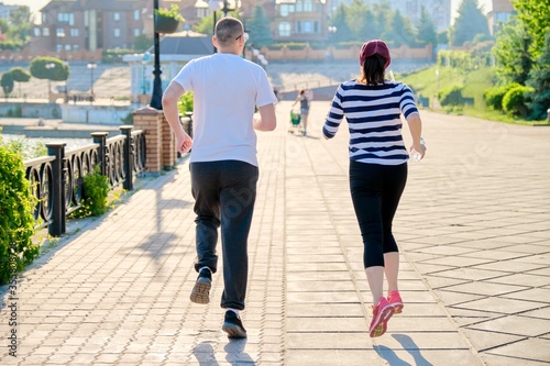 Couple running in city back view, mature man and woman together