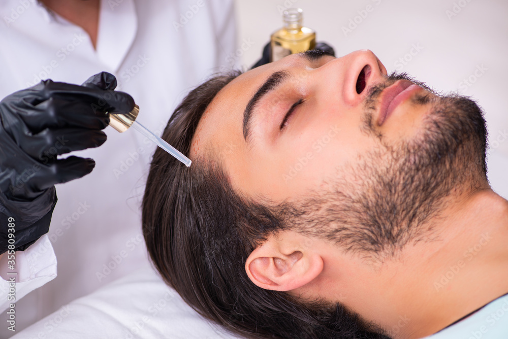 Young man visiting female beautician in hair transplantation con Young man visiting female beautician in hair transplantation con