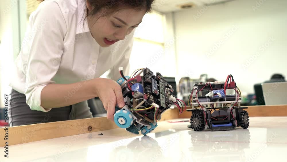 Asian engineer collaborating development robot in modern laboratory. Developers experiment control microchip and build electronics. concept of technology, robotic engineering, and industrial robot. Asian engineer collaborating development robot in modern laboratory. Developers experiment control microchip and build electronics. concept of technology, robotic engineering, and industrial robot.