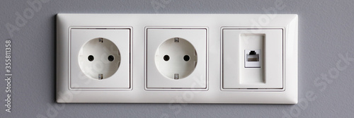 Foto Modern white house outlet on gray wall closeup object