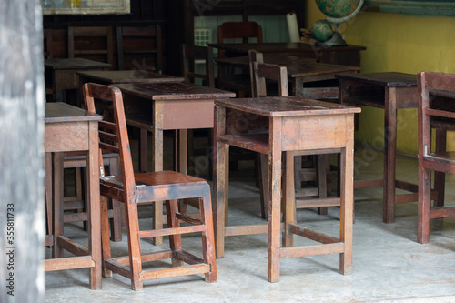 old wooden table for Thai student in urban school. dirty timber desk no student in classroom. Concept   shortage school equipment. school closure caused coronavirus or Coivd-19.