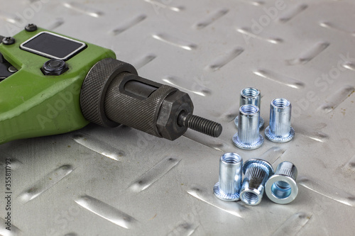 Tool for mounting steel rivets with carvings on a metal background.