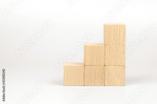 Cube wooden block toy stacked without graphics for Business design concept and build activity for children play create and practices foundation stage.