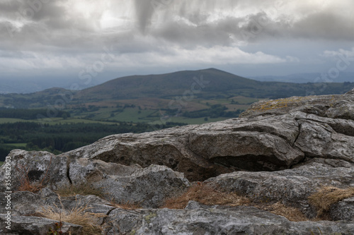 A Welsh mountain viewed from a rock in the Shropshire Hills with dark clouds