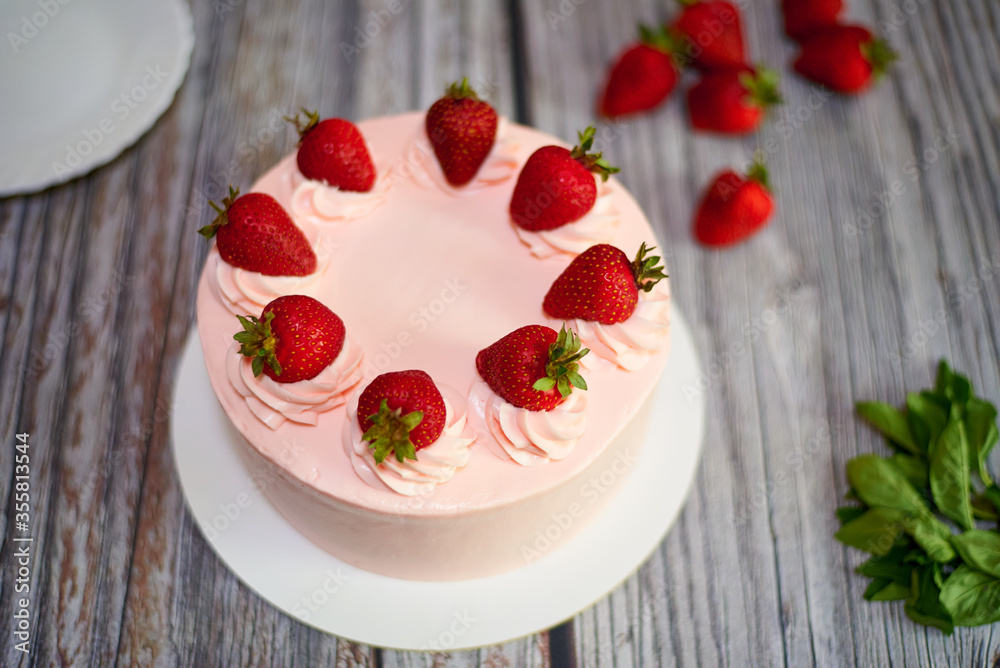 Creamy cake with strawberries on a wooden background. Creamy cake with strawberries on a wooden background.