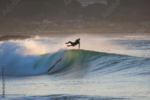 Surfing in Japan, man riding a surfboard in the pacific ocean near Tokyo photo