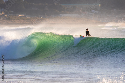 Surfing in Japan, man riding a surfboard in the pacific ocean near Tokyo photo