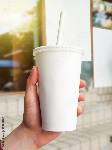  Man hand holding white paper coffee cup.