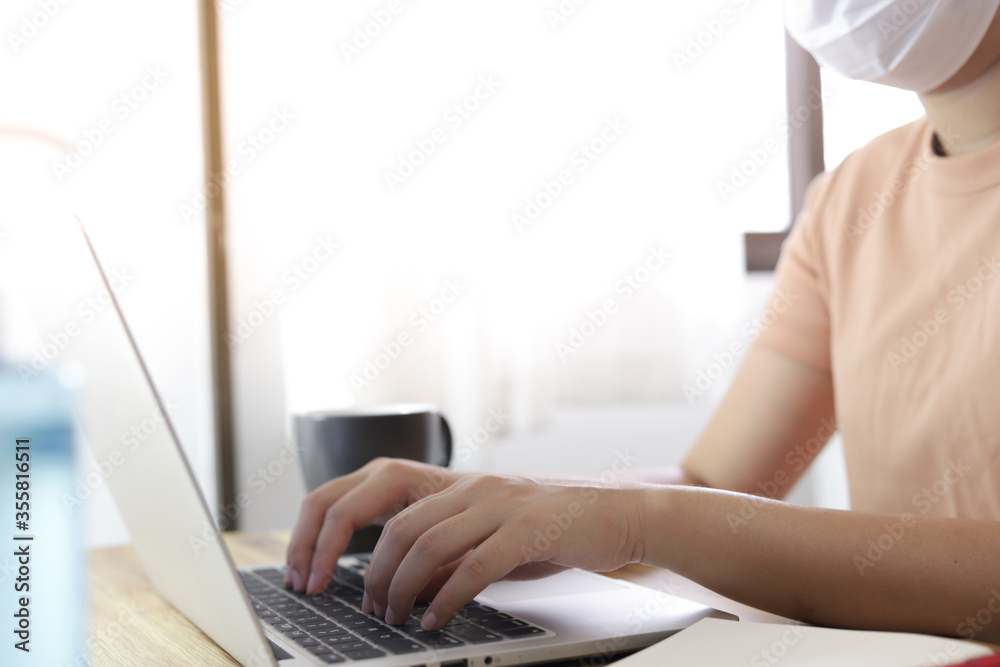 Fototapeta premium Woman working from home. wearing protective mask. COVID-19 Pandemic Coronavirus home isolation auto quarantine wearing face mask protective for spreading of disease virus SARS-CoV-2. Working from home